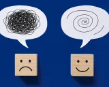 Dwa dymki myśli: jeden z chaotyczną linią, drugi ze spiralą. Pod nimi kostki z minami: smutną i uśmiechniętą. Przykłady zaburzeń emocjonalnych i ich przezwyciężania.
