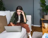 Introwertyczka skupiona na pracy przy laptopie na kanapie. Idealna praca dla introwertyka, gdzie można pracować w spokoju.